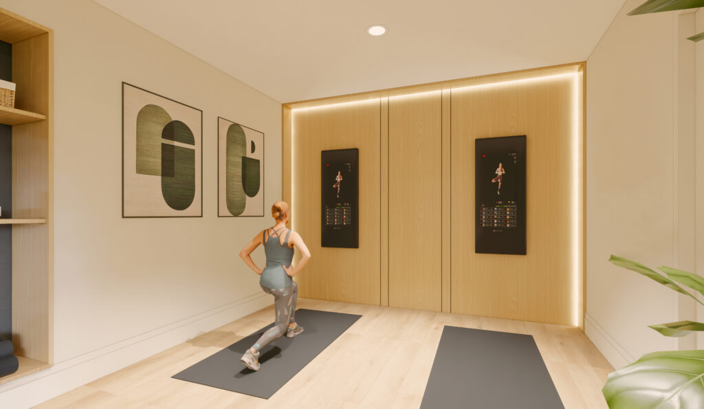 A woman in athletic wear does lunges on a yoga mat in a modern home gym with wooden floors, wall-mounted fitness screens, abstract artwork, and bright lighting.